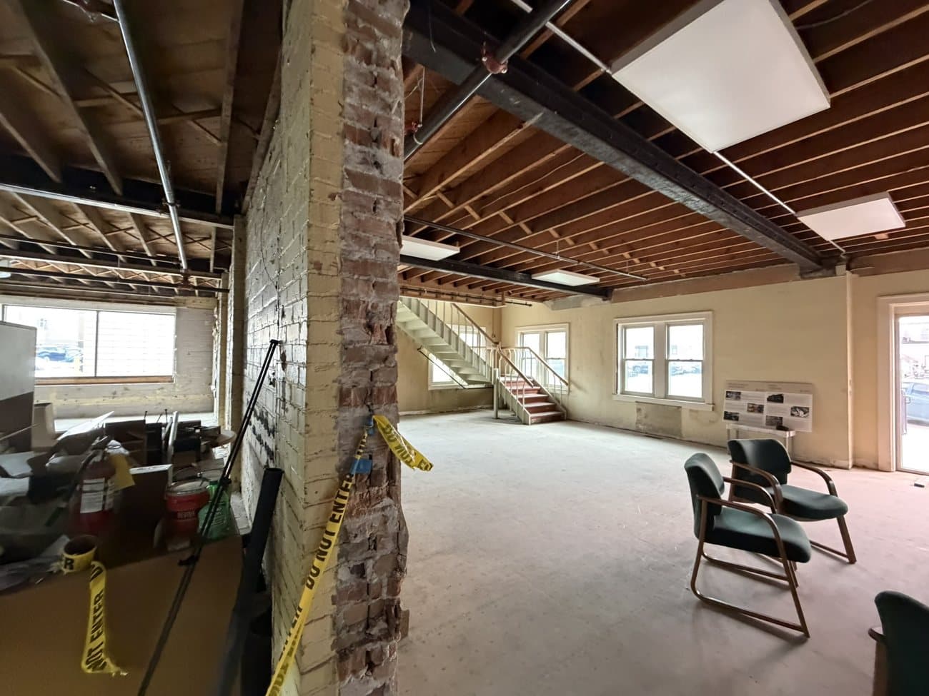 Exposed brick and a historic staircase on an upper floor